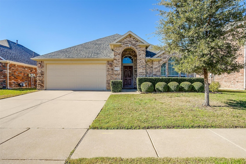 view of front of property with a garage and a front yard