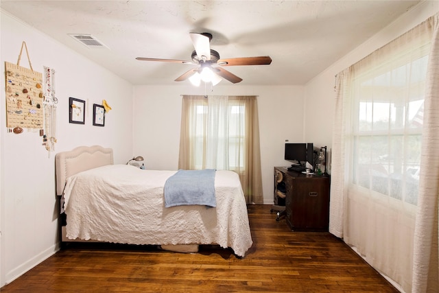 bedroom with crown molding, ceiling fan, and dark wood-type flooring