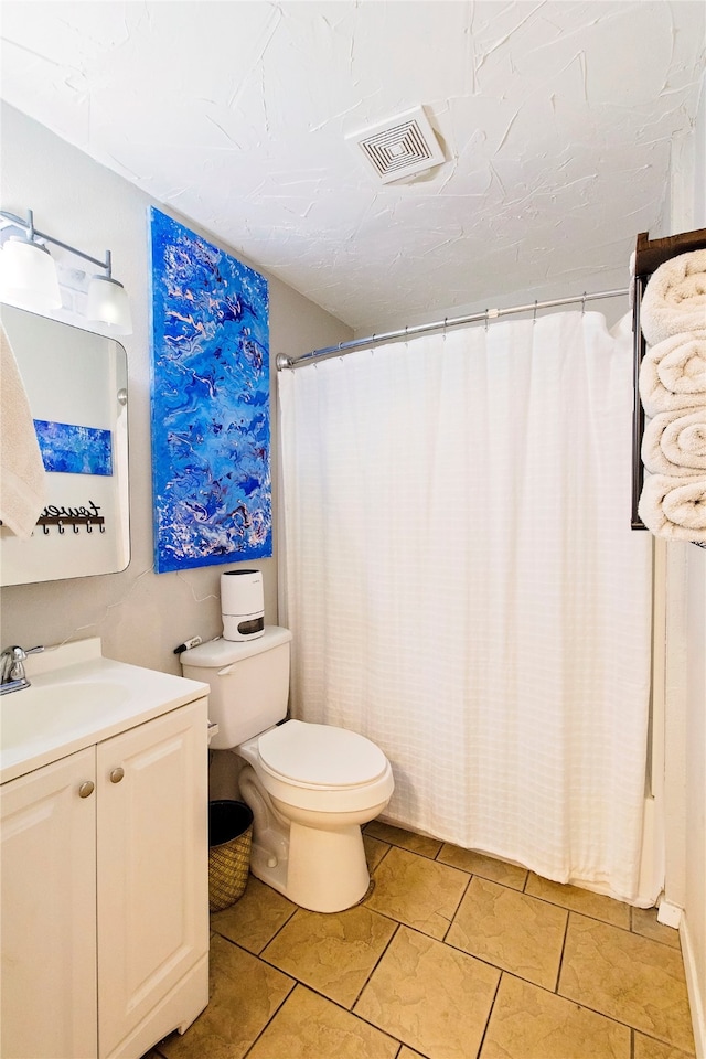 bathroom with tile patterned floors, vanity, and toilet