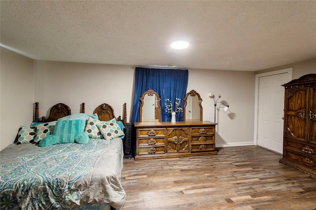 bedroom with wood-type flooring and a textured ceiling