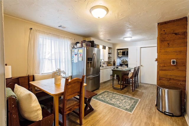 dining area featuring light wood-type flooring and sink