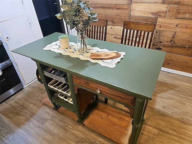 dining space featuring wood walls and wood-type flooring