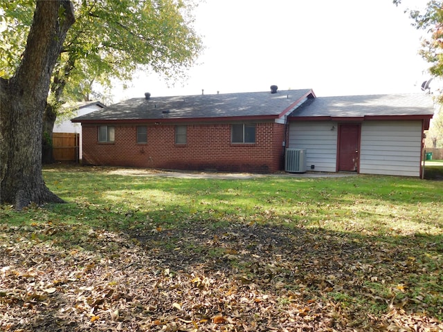 rear view of house with a yard and central AC