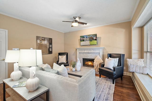 living room featuring crown molding, dark hardwood / wood-style flooring, ceiling fan, and a brick fireplace