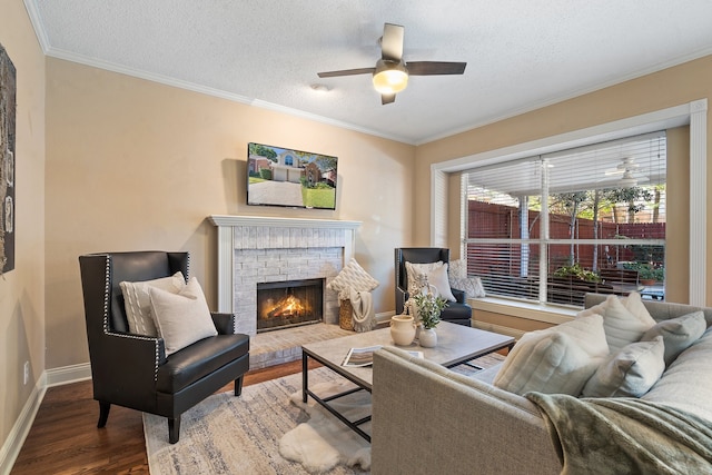 living room with a fireplace, hardwood / wood-style floors, a textured ceiling, and ornamental molding