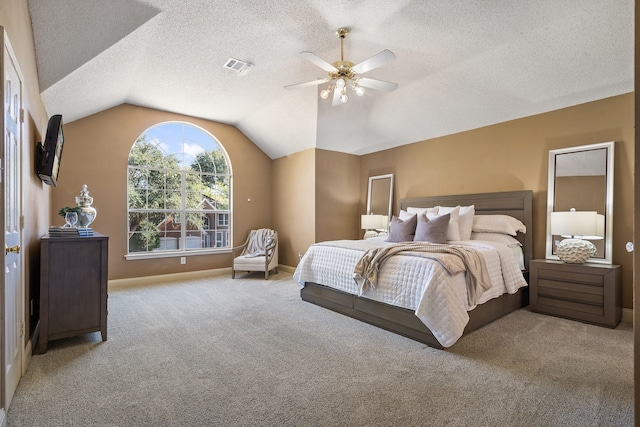 bedroom featuring ceiling fan, light colored carpet, a textured ceiling, and vaulted ceiling