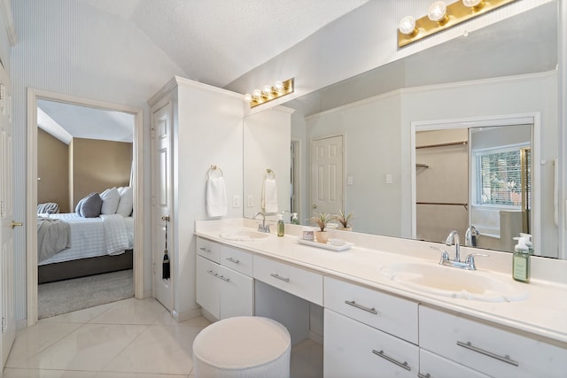 bathroom featuring tile patterned floors, a textured ceiling, vanity, and lofted ceiling