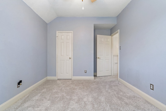 unfurnished bedroom with light carpet and lofted ceiling