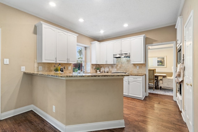 kitchen with kitchen peninsula, light stone counters, a textured ceiling, dark wood-type flooring, and white cabinets