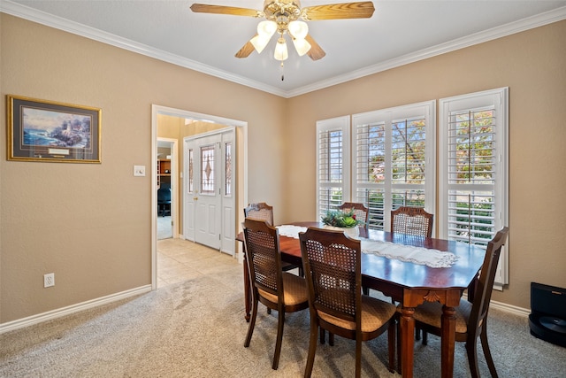 dining area with light carpet, ceiling fan, and crown molding