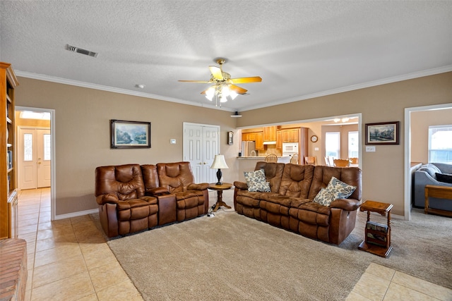 tiled living room featuring a textured ceiling, ceiling fan, and ornamental molding