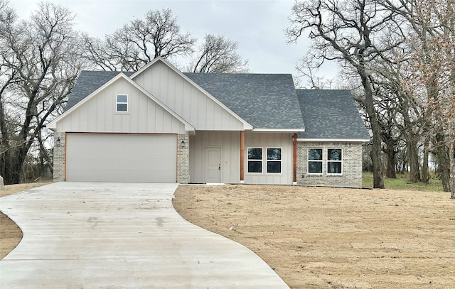 modern farmhouse style home featuring driveway, roof with shingles, an attached garage, board and batten siding, and brick siding