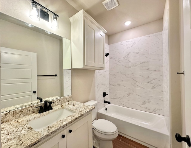 full bathroom with hardwood / wood-style flooring, vanity, toilet, and tiled shower / bath