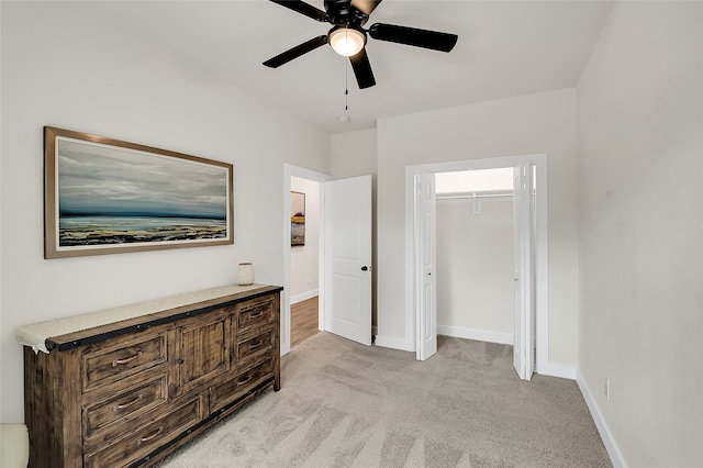 bedroom with ceiling fan, light colored carpet, and a closet