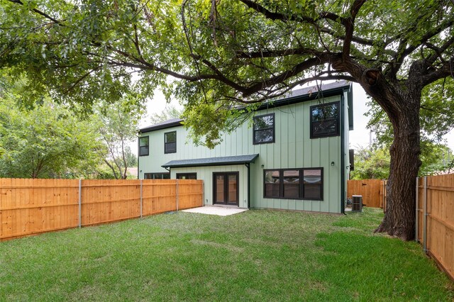 rear view of property featuring central AC, a patio area, and a lawn