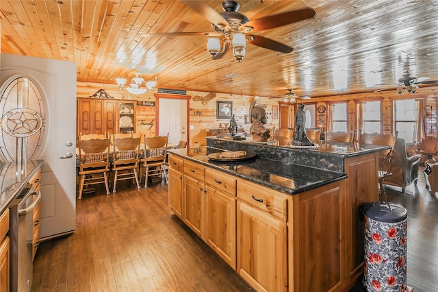 kitchen featuring a center island, wood walls, wooden ceiling, dark wood-type flooring, and dark stone countertops