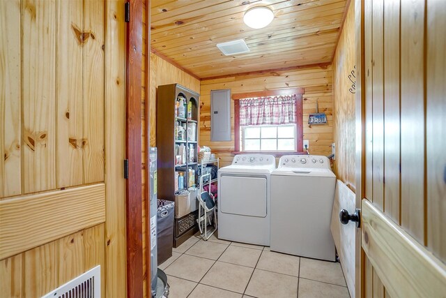 laundry room with washing machine and dryer, light tile patterned floors, wood ceiling, and wooden walls