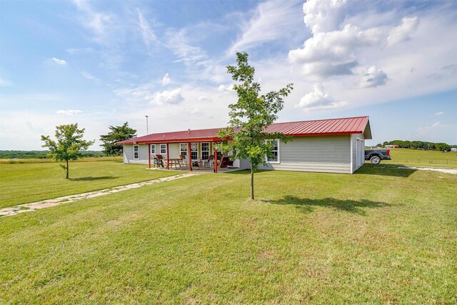 rear view of property featuring a patio area and a lawn