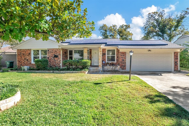 ranch-style house featuring solar panels, a garage, and a front lawn