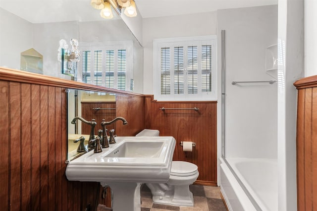 full bathroom with tile patterned floors, toilet, a wealth of natural light, and bathtub / shower combination