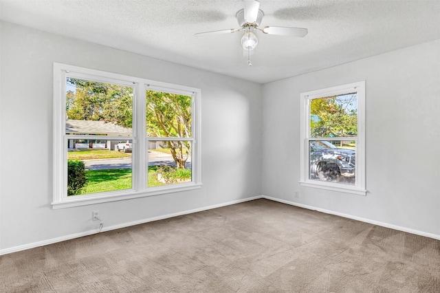 carpeted empty room with ceiling fan and a textured ceiling