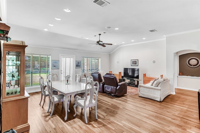 dining area with ceiling fan, lofted ceiling, crown molding, and light hardwood / wood-style flooring