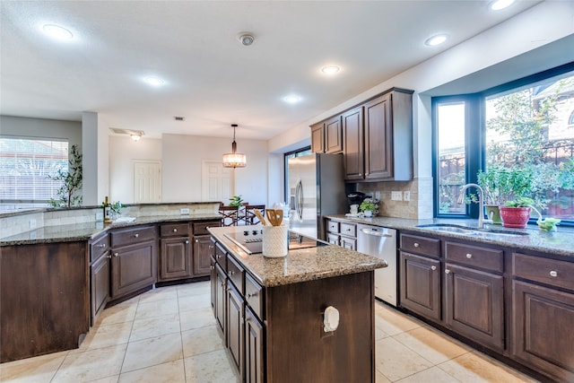 kitchen featuring plenty of natural light, a kitchen island, sink, and stainless steel appliances