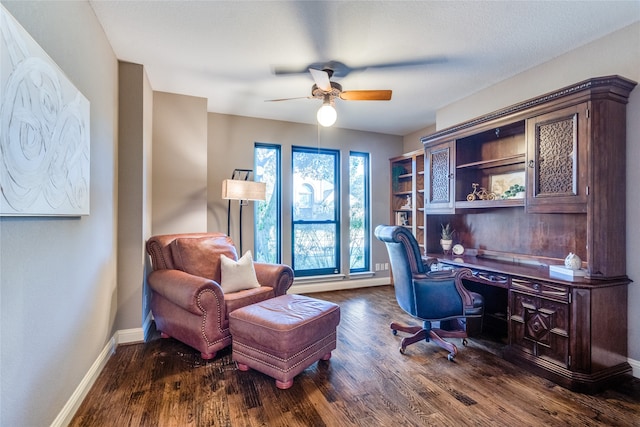 office area featuring dark hardwood / wood-style flooring, ceiling fan, and built in desk