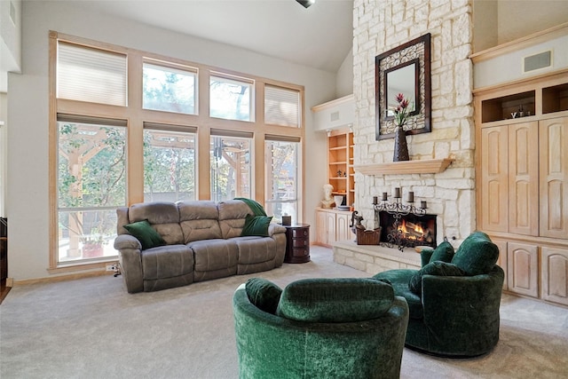 carpeted living room featuring a fireplace and high vaulted ceiling