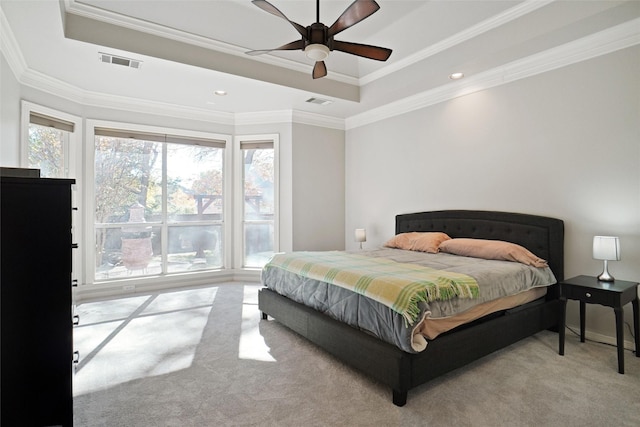 carpeted bedroom featuring ceiling fan, ornamental molding, and a raised ceiling