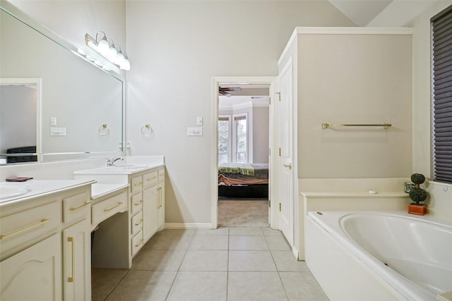 bathroom featuring ceiling fan, a tub to relax in, vanity, and tile patterned flooring