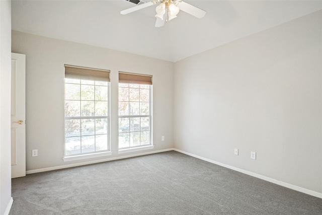 carpeted spare room featuring ceiling fan and vaulted ceiling