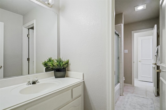 bathroom with vanity and shower / bath combination with glass door