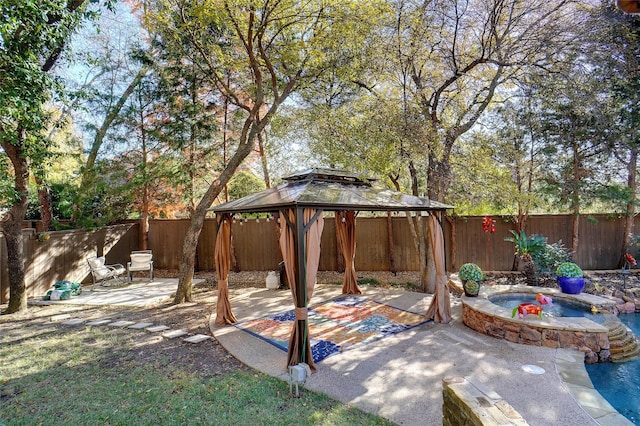 view of patio with a gazebo and an in ground hot tub