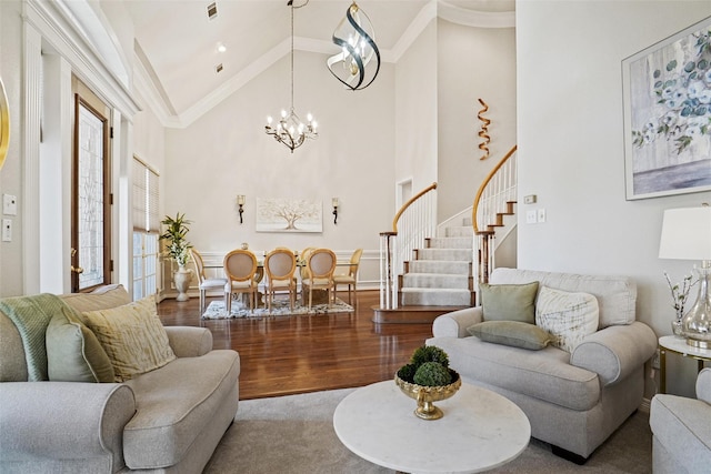 living room featuring wood-type flooring, ornamental molding, a notable chandelier, and high vaulted ceiling