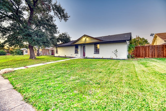 ranch-style home featuring a lawn