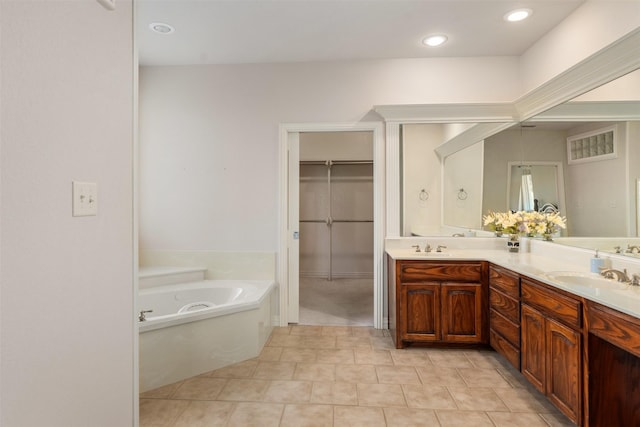 bathroom featuring tile patterned floors, vanity, and a washtub