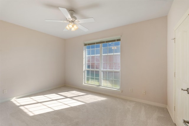 carpeted spare room featuring ceiling fan