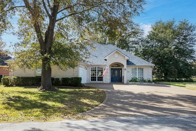 view of front of home with a garage and a front lawn