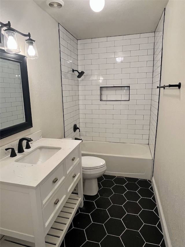 full bathroom featuring tile patterned flooring, vanity, toilet, and tiled shower / bath