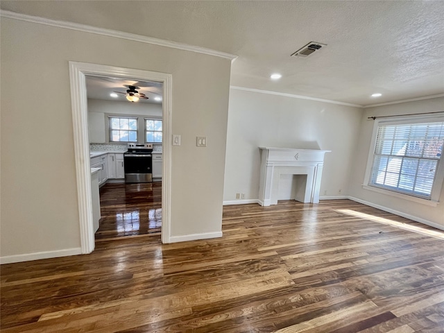 unfurnished living room featuring ceiling fan, dark hardwood / wood-style flooring, a textured ceiling, and crown molding