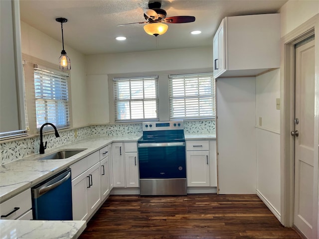 kitchen featuring dark wood-type flooring, white cabinets, sink, appliances with stainless steel finishes, and decorative light fixtures