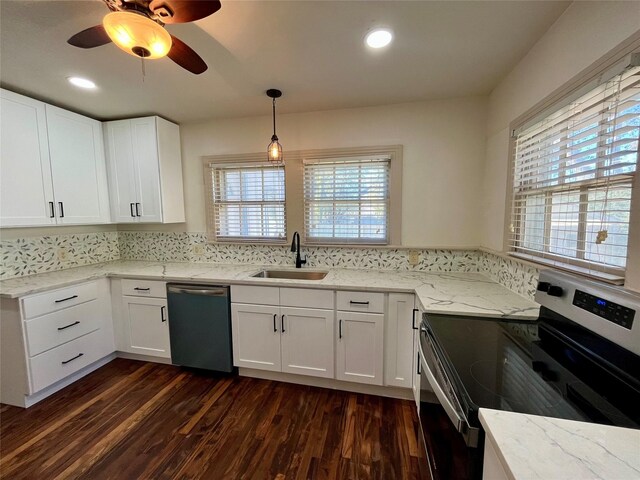 kitchen featuring stainless steel appliances, a healthy amount of sunlight, sink, decorative light fixtures, and dark hardwood / wood-style floors