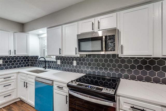 kitchen with backsplash, stainless steel appliances, dark wood-type flooring, sink, and white cabinetry