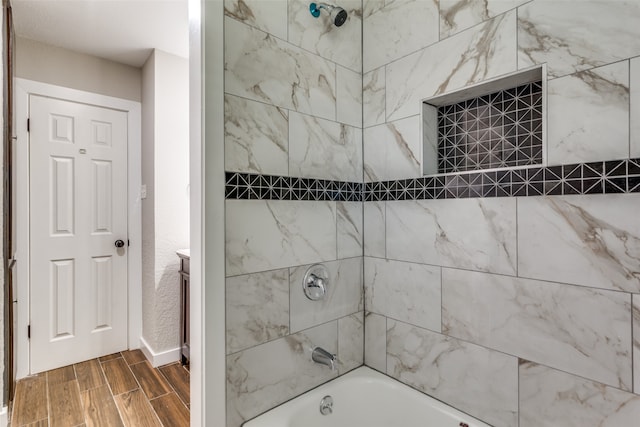 bathroom featuring tiled shower / bath combo and vanity