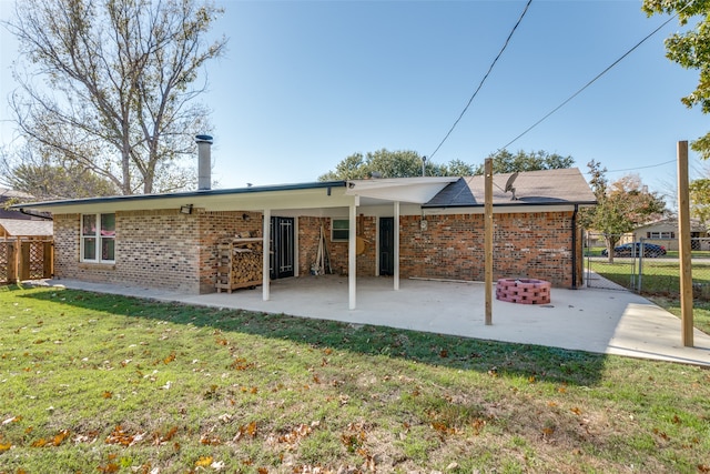 rear view of property with a lawn and a patio