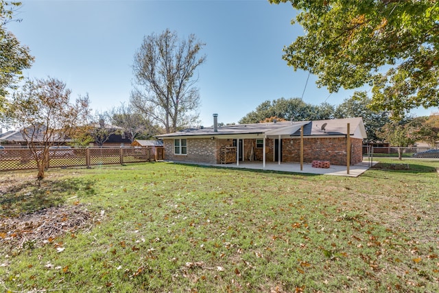 back of property with a yard and a patio