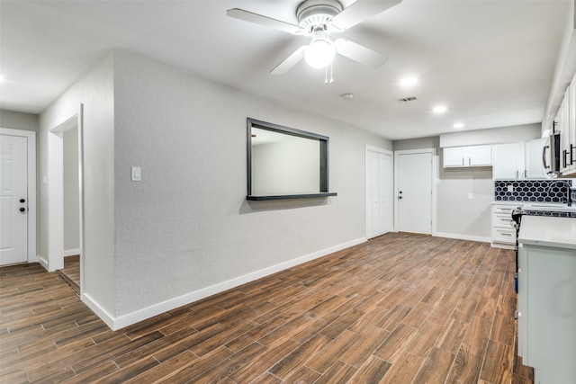 kitchen with white cabinets, ceiling fan, dark hardwood / wood-style flooring, and tasteful backsplash