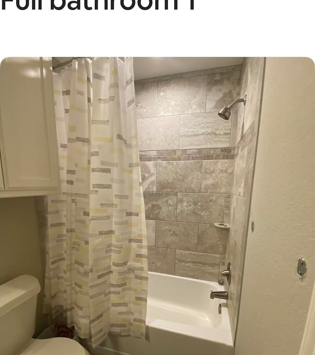 bathroom featuring shower / tub combo and toilet