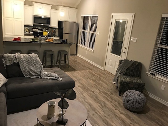 living room with wood-type flooring and lofted ceiling